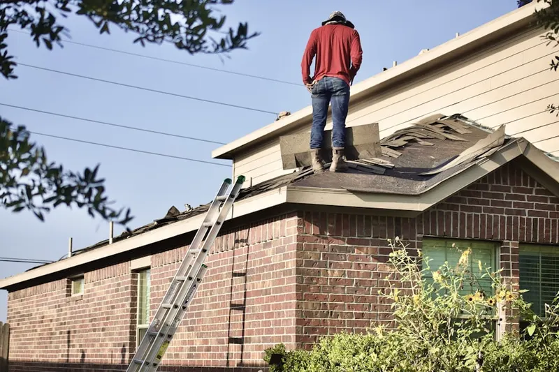 Professional roofer working on a residential roof in Keister